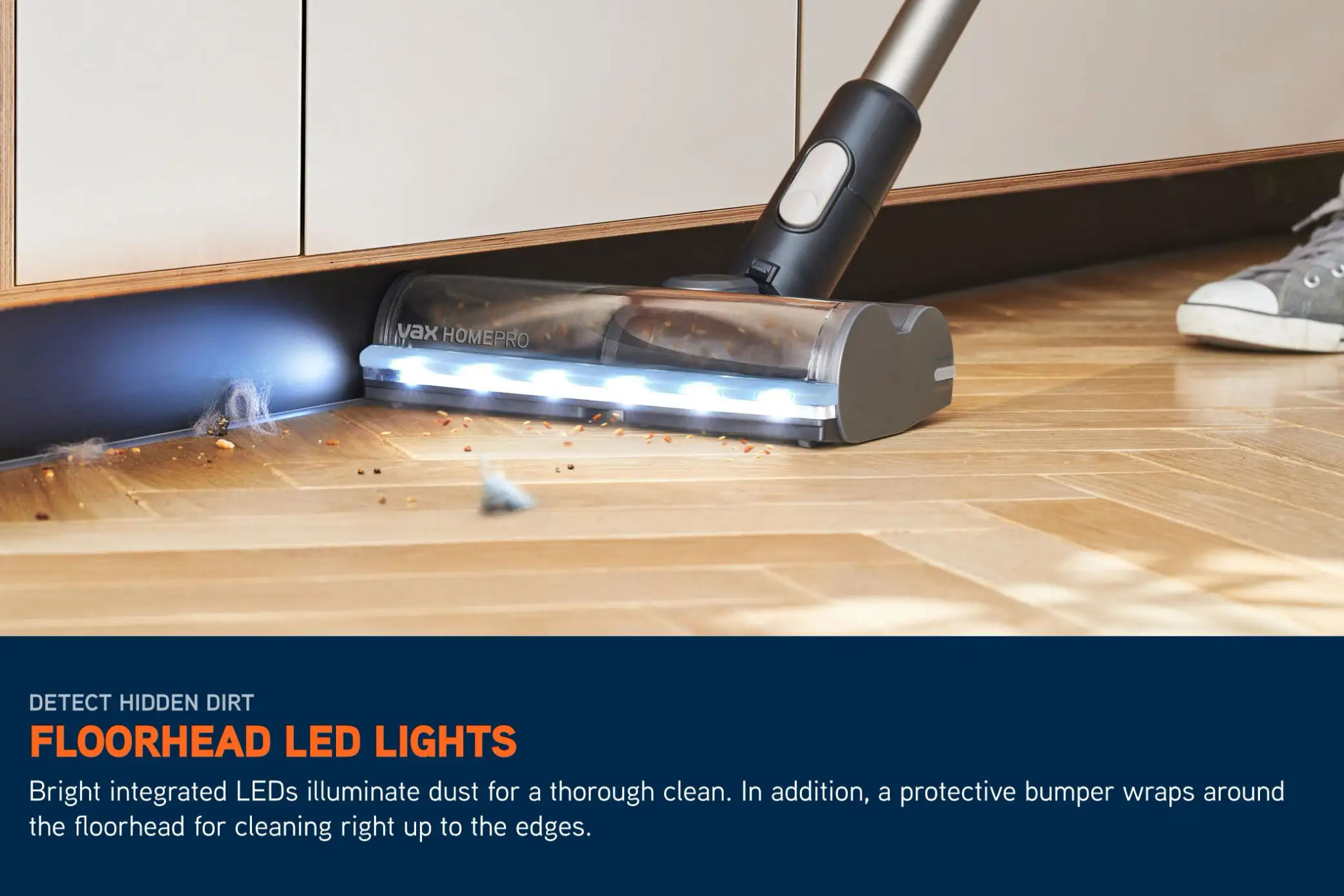 LED lights on a cordless HomePro vacuum illuminating the floor ahead, picking up crumbs and dirt on a hard floor