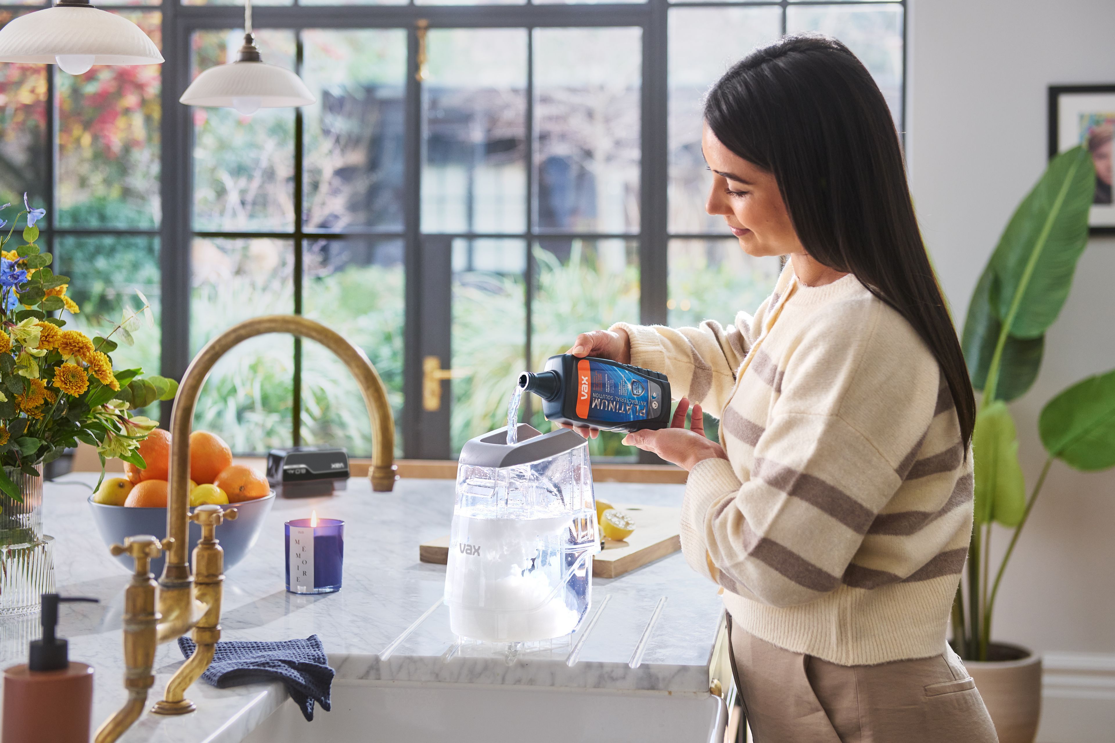 Platinum Antibacterial Carpet Cleaning Solution being poured into the VAX ONEPWR Compact Cordless Carpet Cleaner tank 